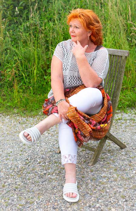 Graziella Coppoletta - Kraftpotenzial Graziella Coppoletta sitzt in einem Gartemstuhl und stützt das Kinn auf die Hand.